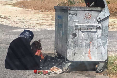 GÜNÜN FOTOĞRAFI: Çöpten çıkardıkları ile çocuğunu doyuran anne
